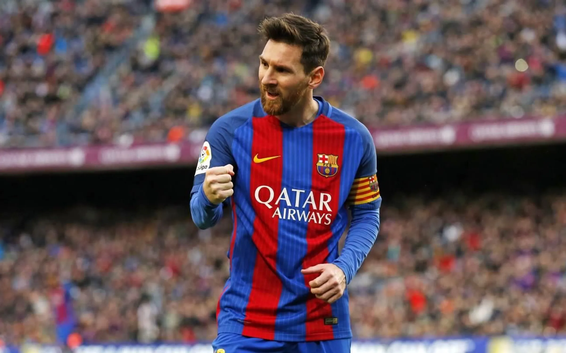 Lionel Messi sitting beside a football